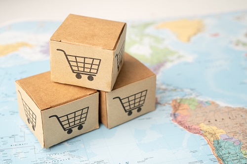 Boxes stamped with shopping cart logos on a map of the world. 