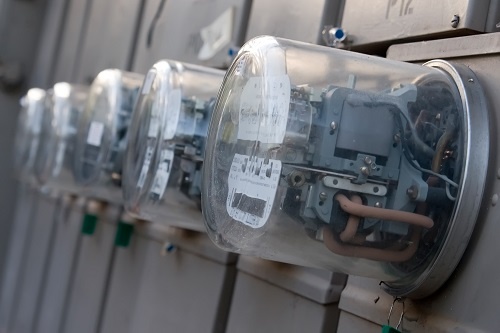 A row of electric meters measuring power use.
