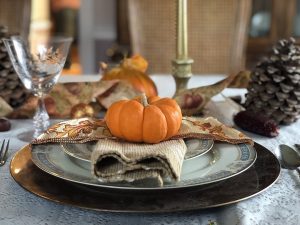 voicemail greeting for thanksgiving shows a pumpkin on a exquisitely wrapped set of china with a fancy napkin