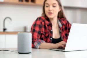 voice recording for virtual assistants as woman speaks to smart speaker