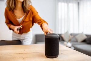 voice recording for virtual assistants as woman turns on smart speaker