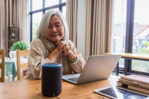 voice recording for virtual assistants as older asian woman interacts with her smart speaker