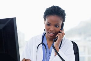 a black doctor speaks to her patient with the help of IVR prompts for hospitals